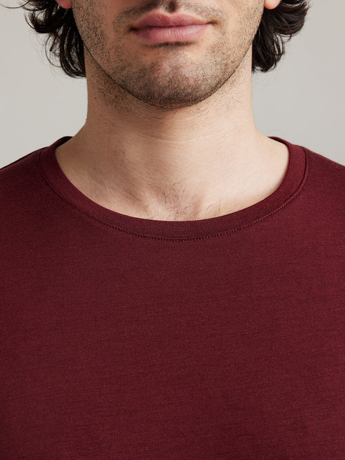 Detail van ronde ribkraag van een bordeauxrode merino wol T-shirt voor mannen