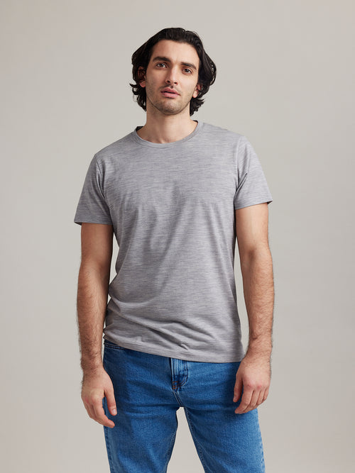 Man draagt lichtgrijs gemêleerd merinowollen T-shirt met ronde hals en korte mouwen van Wolk