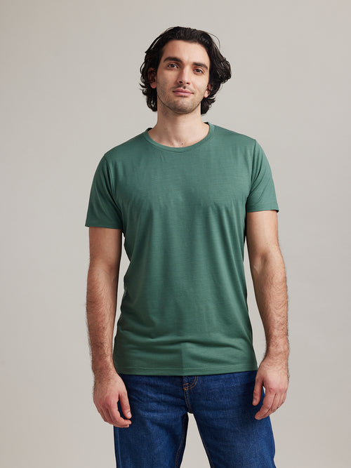 man draagt een dennengroen merinowollen T-shirt met korte mouwen en ronde hals
