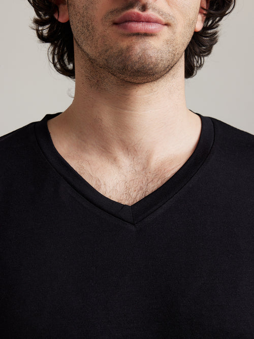 detail van V nek kraag van merino wol T-shirt voor mannen in zwart