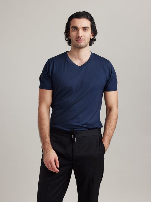 Man wears V neck merino wool T-shirt in navy color and short sleeves regular fit